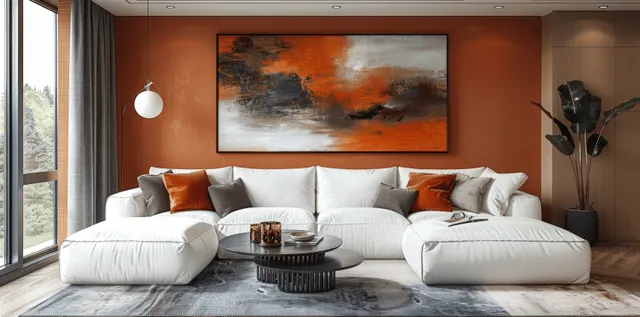 White sectional sofa with orange cushions in front of a peach abstract painting on a terracotta wall.