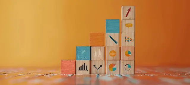 Stacked wooden blocks with business growth chart icons rise on a warm orange background.