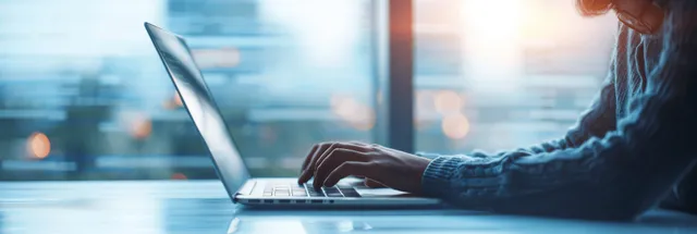 Businesswoman Typing on Laptop in Office with Blurred City Lights