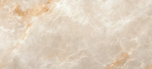 Beige marble surface close-up with fine veining and warm stone highlights across a textured background.