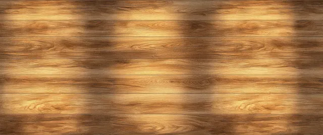 Sunlit wooden planks showing warm patterned shadows and visible wood grain texture.