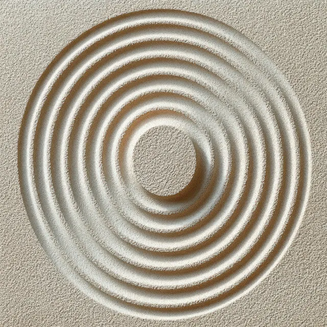 Carved concentric circular patterns pressed into beige sand with soft shadowed depth