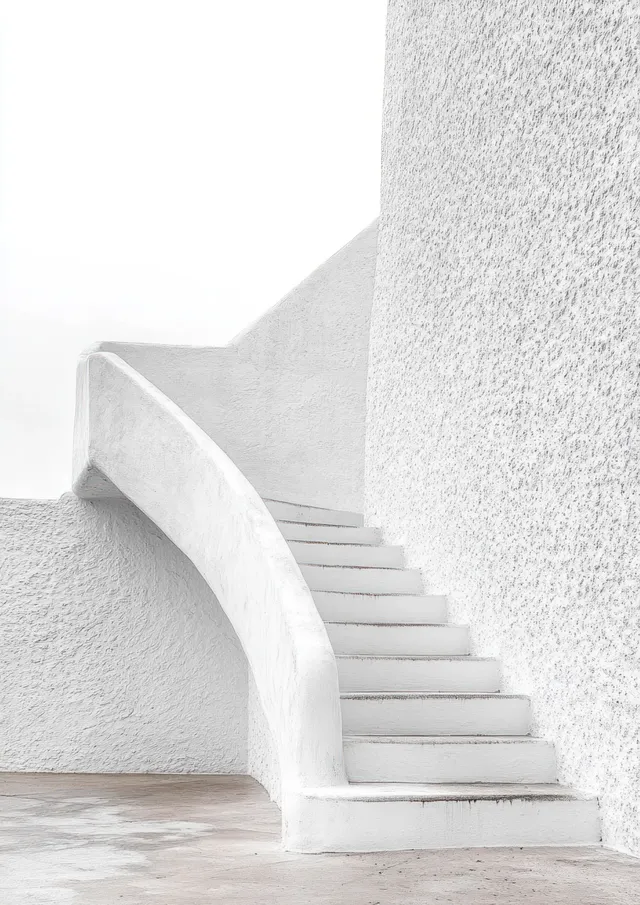 Minimal white concrete staircase curves upward along a textured wall under bright natural light.