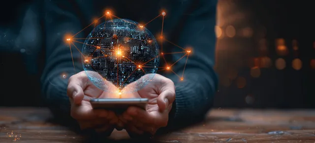 Businessman holding a glowing hologram globe while AI chat and network icons appear above a laptop on a dark desk.