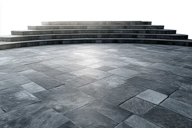 Curved gray stone steps and textured tile flooring forming an empty platform under daylight.