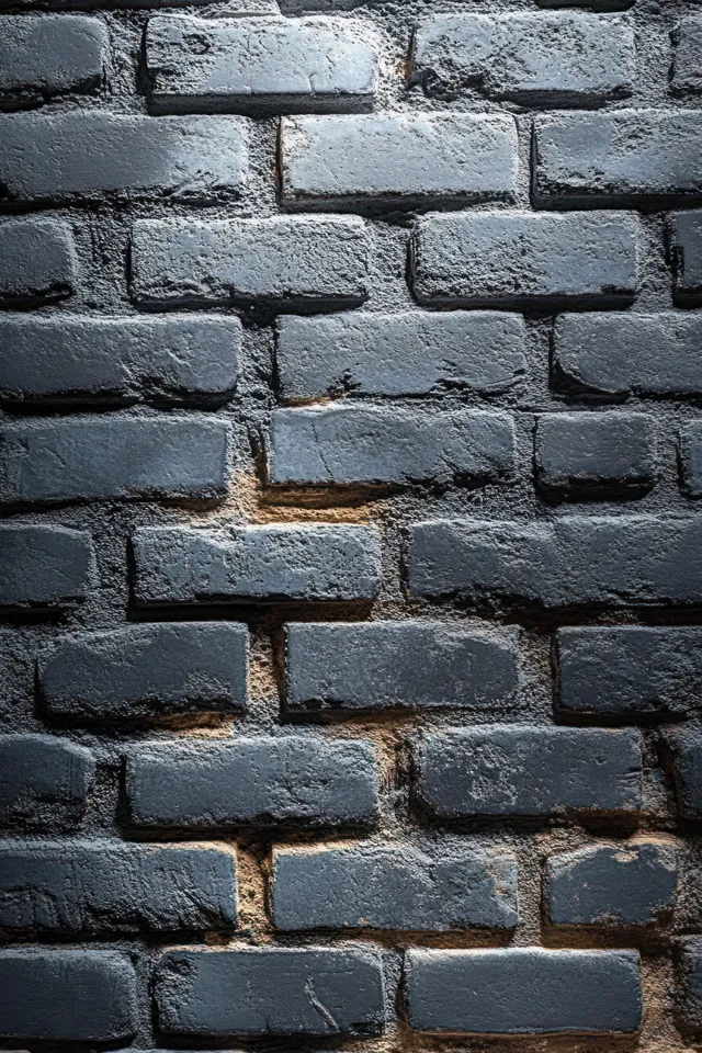 Gray-painted brick wall close-up with rough mortar texture and weathered masonry surface details.