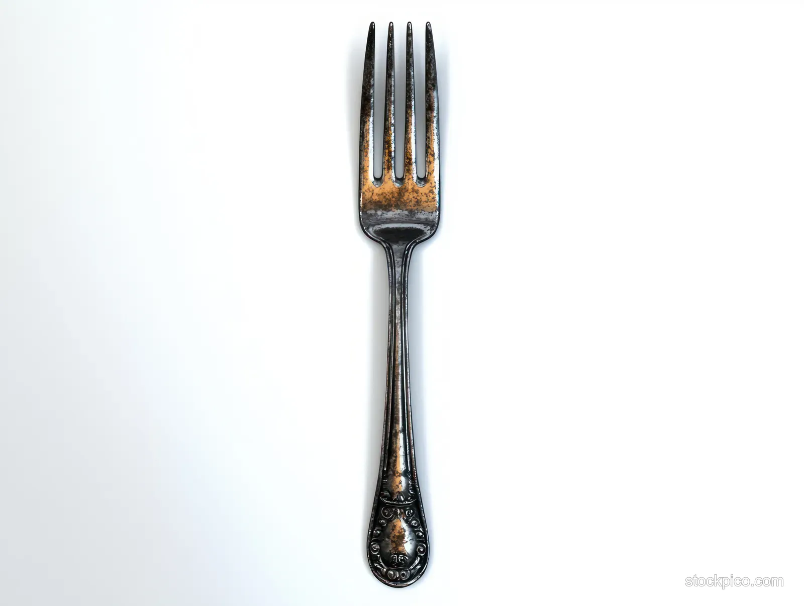 Vintage engraved metal fork with four tines standing on a plain white background.