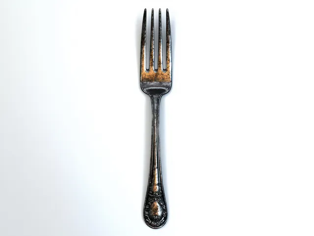 Vintage engraved metal fork with four tines standing on a plain white background.