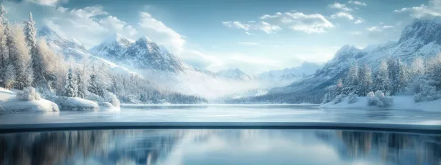Frozen lake reflecting snowy mountains under clear blue winter sky and soft morning haze