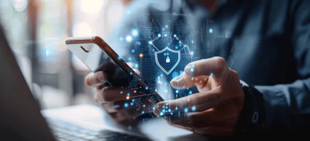 Businessman Using Smartphone and Laptop for Secure Digital Protection