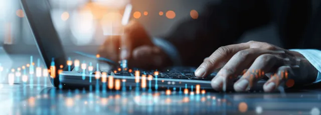 A business analyst calculates growth using a laptop and calculator while reviewing digital financial charts in a modern office.