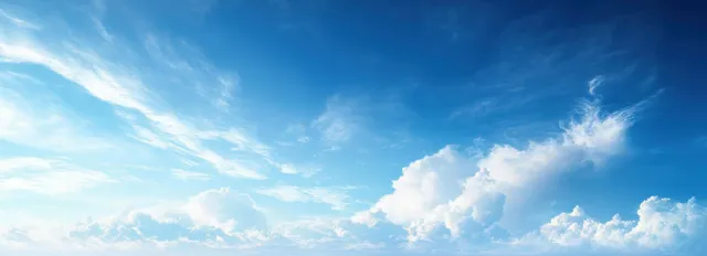 Dreamy blue sky with wispy clouds and soft light across a bright horizon.