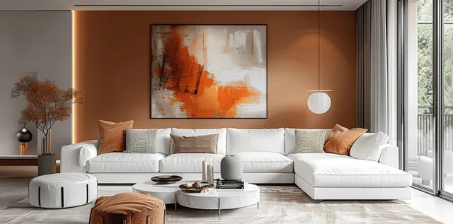 White sectional sofa centered beneath an abstract orange painting on a terracotta wall, with cushions, coffee table, and bright window light.