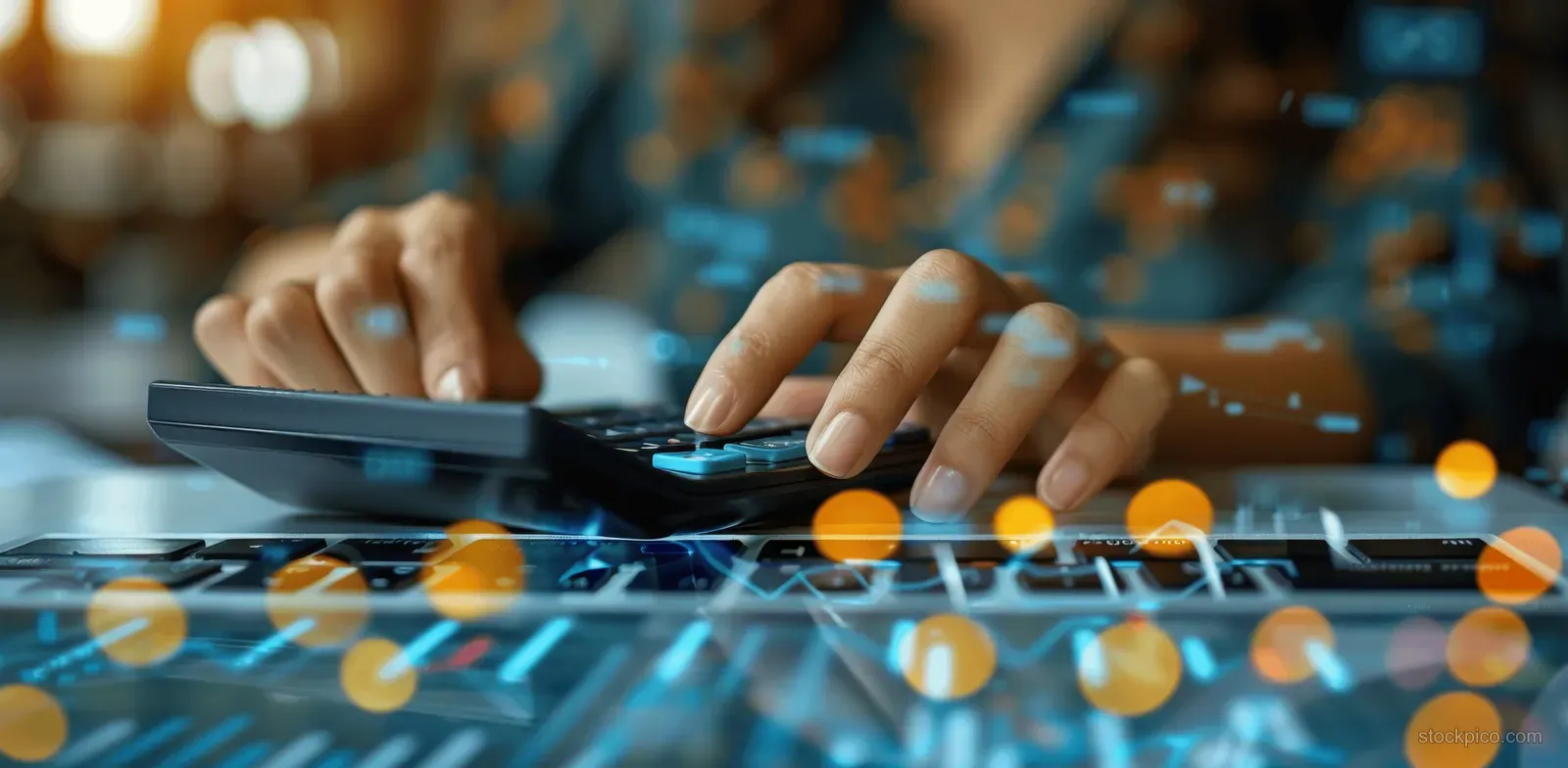 A businesswoman is budgeting with a calculator and laptop at her office desk.