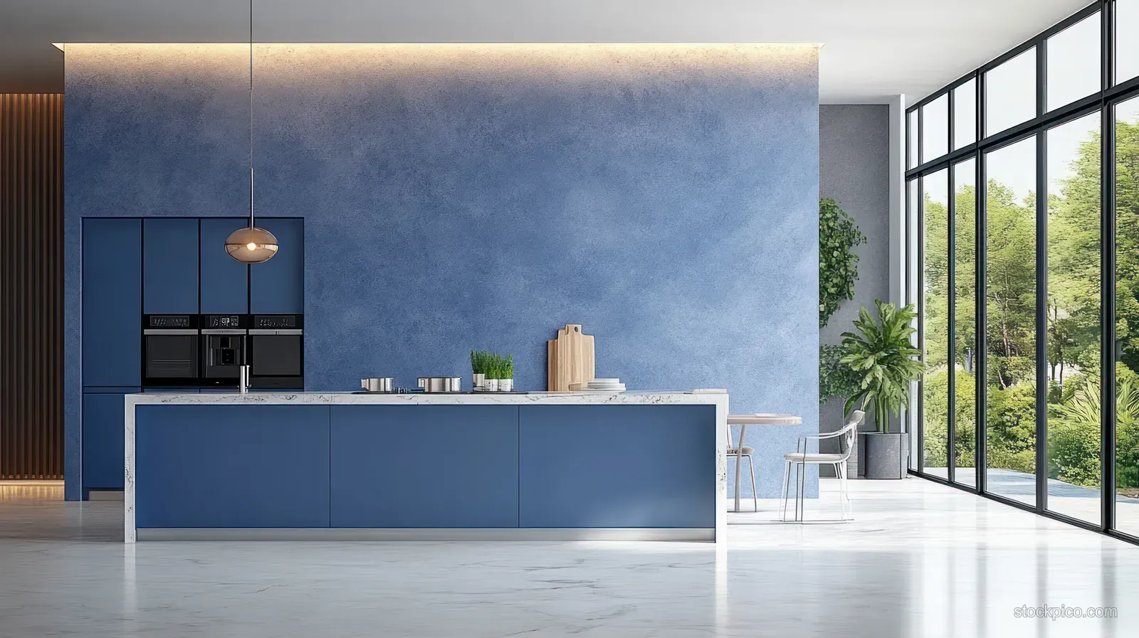 Sunlit minimalist kitchen interior with blue cabinets, marble countertop, stools, and large windows.