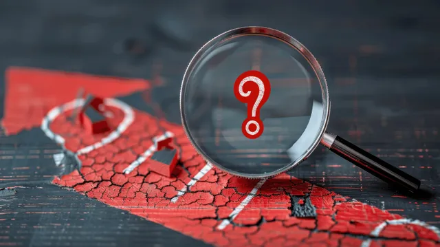 Magnifying glass over cracked red warning symbol with exclamation mark on dark surface