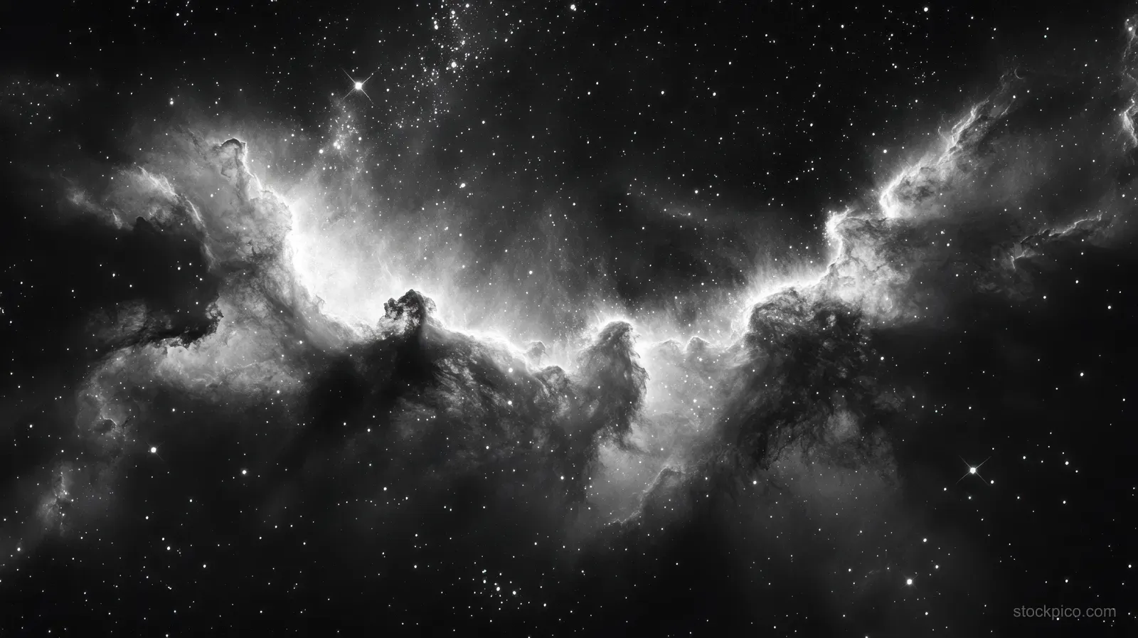Black-and-white nebula with glowing gas, bright star clusters, and dark dust clouds across deep space.