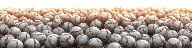Close-up pile of baseballs with visible seams under soft natural light