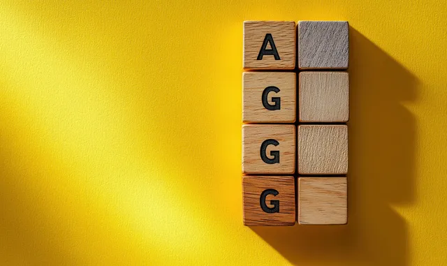 Wooden letter blocks spelling agenda placed on a yellow background with empty space for text.
