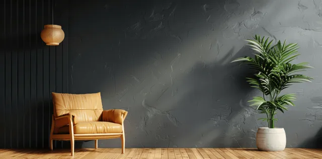 Tan leather armchair sits on a wooden floor beside a dark gray wall with a pendant lamp and potted plant.