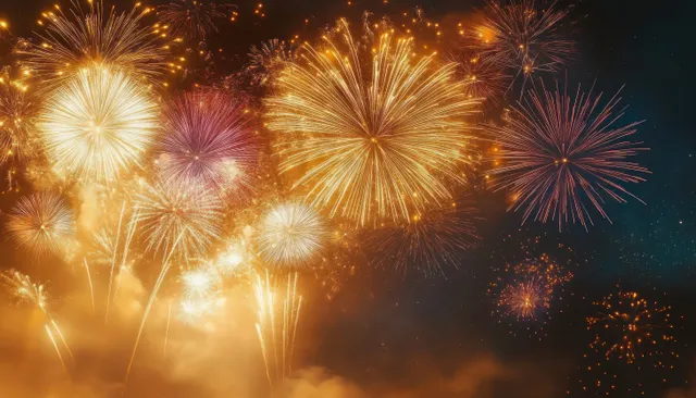 Golden fireworks burst across a dark night sky above a glowing festival haze.