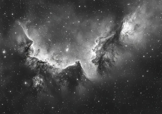 Black and white nebula clouds illuminated by scattered stars across deep space backdrop