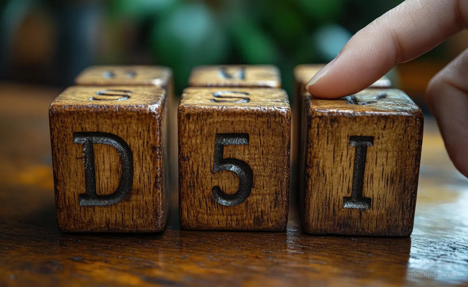 A hand rotates wooden blocks labeled D 4 5 on a table to suggest DSM-IV to DSM-5 update.