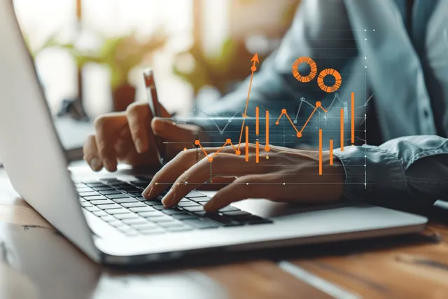 Businessman typing on laptop while analyzing financial charts and digital growth overlay in office