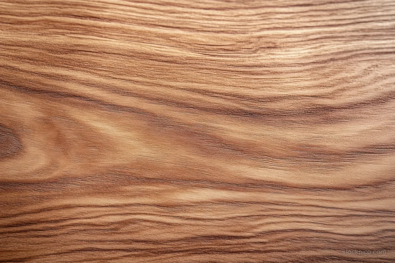 Close-up of warm brown wood surface with flowing grain patterns and smooth texture.