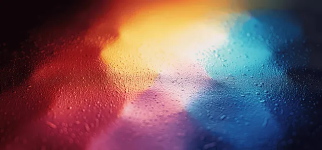 Dark grainy abstract background with glowing wave-like gradients in teal, red, and orange.