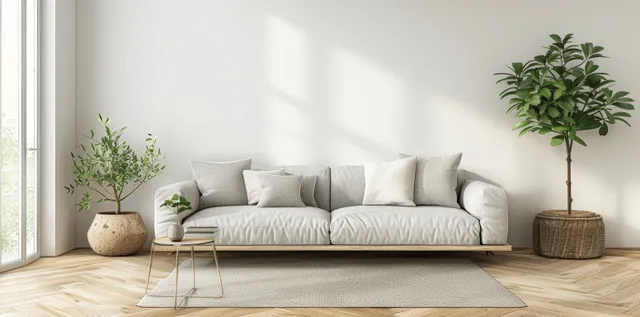 Minimalist Scandinavian living room with light sofa, side table, potted plants, and a large window over a wooden floor.