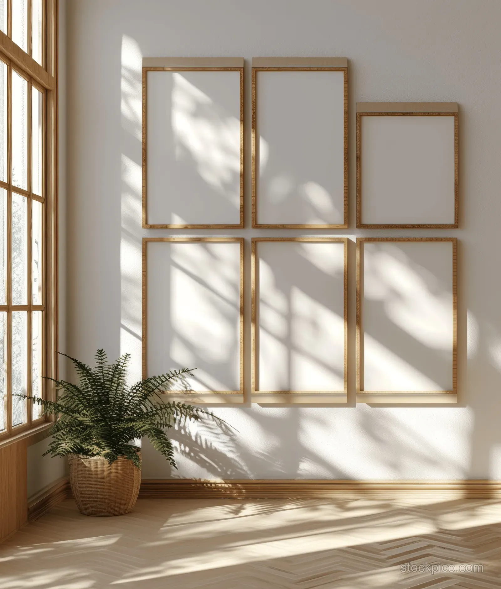 Sunlit wall displays several blank poster frames with soft shadows and glass reflections in a cozy room.