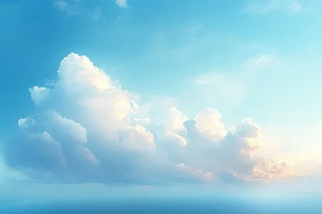 Fluffy white cumulus clouds glow softly in a bright blue sky above a calm ocean horizon.