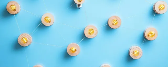 Interconnected small light bulbs on wooden bases with string links across a blue background