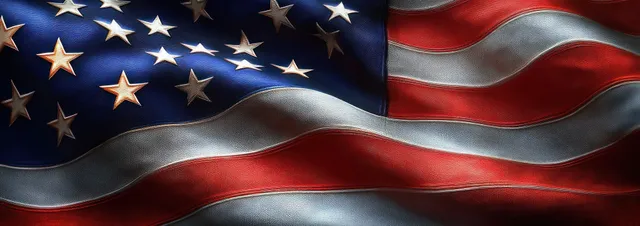 An American flag fills the frame, waving with visible stars, stripes, and textured fabric under dramatic light.