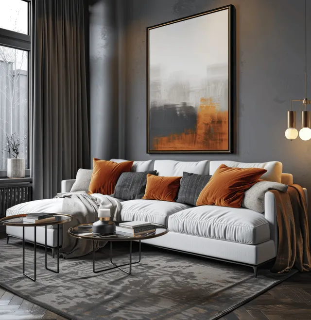 White sofa with orange pillows sits beside a coffee table in a dark living room with black curtains and a framed artwork.
