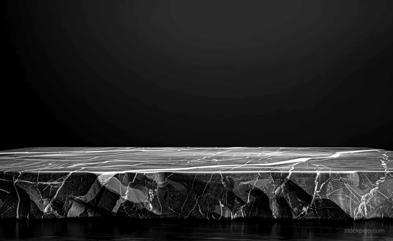 Glossy black marble slab with intricate white veins resting on a dark background.