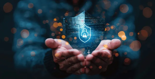 Businessman’s hands present a glowing shield icon representing insurance protection against health and property risks.