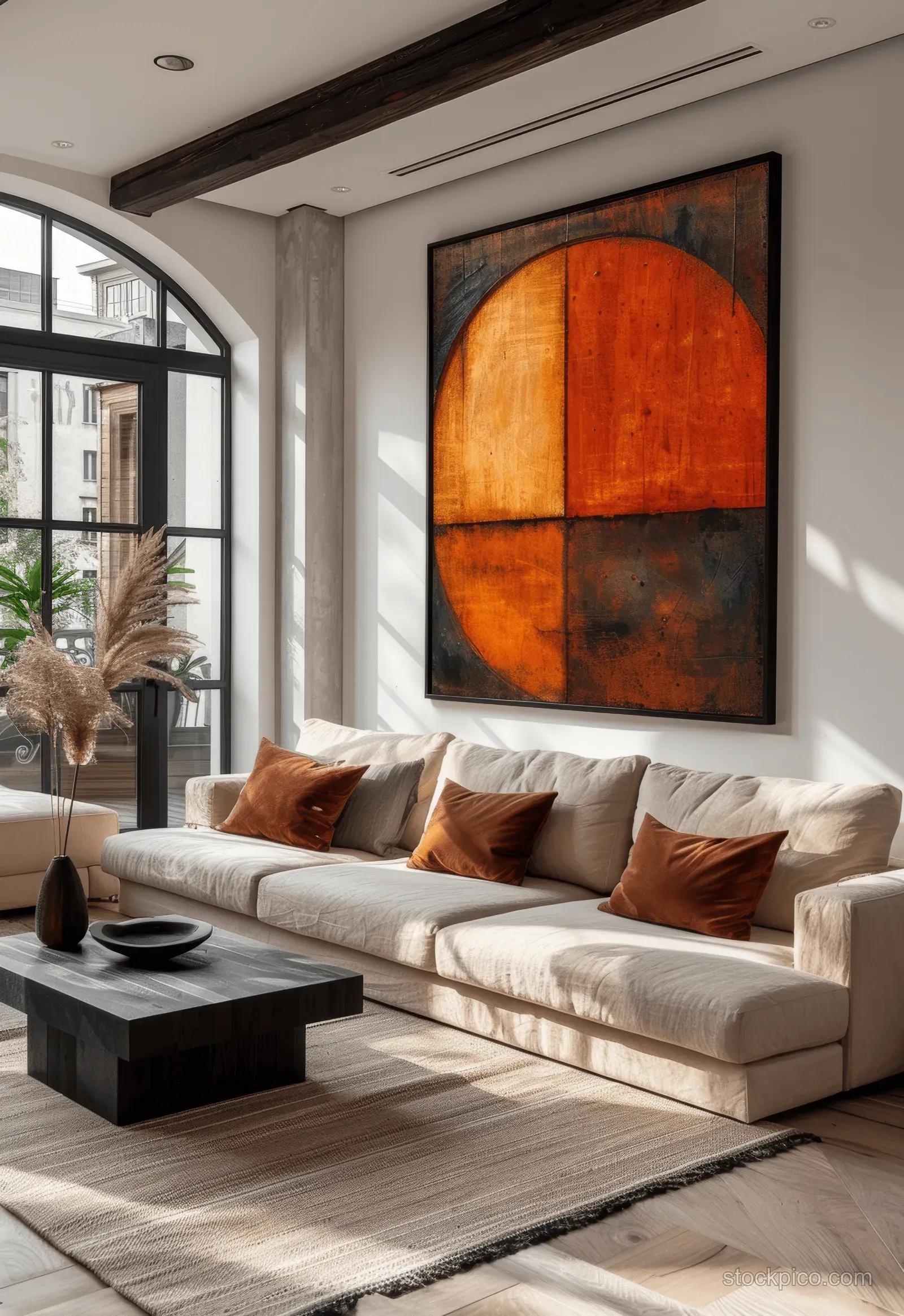 Beige sofa and black coffee table sit beneath terracotta abstract art in a bright minimalist living room.