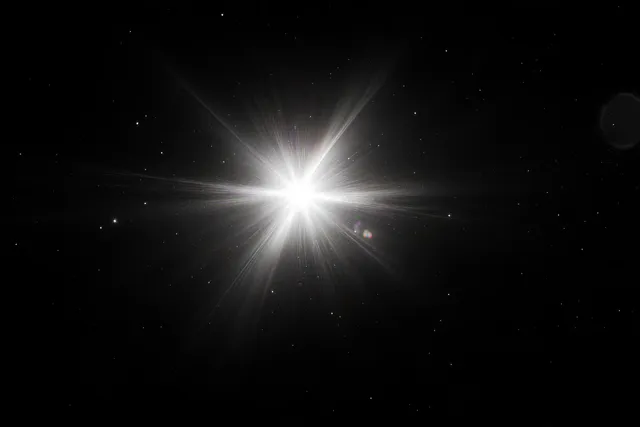 A bright starburst emits radiant beams over a dark night sky with scattered twinkling stars.