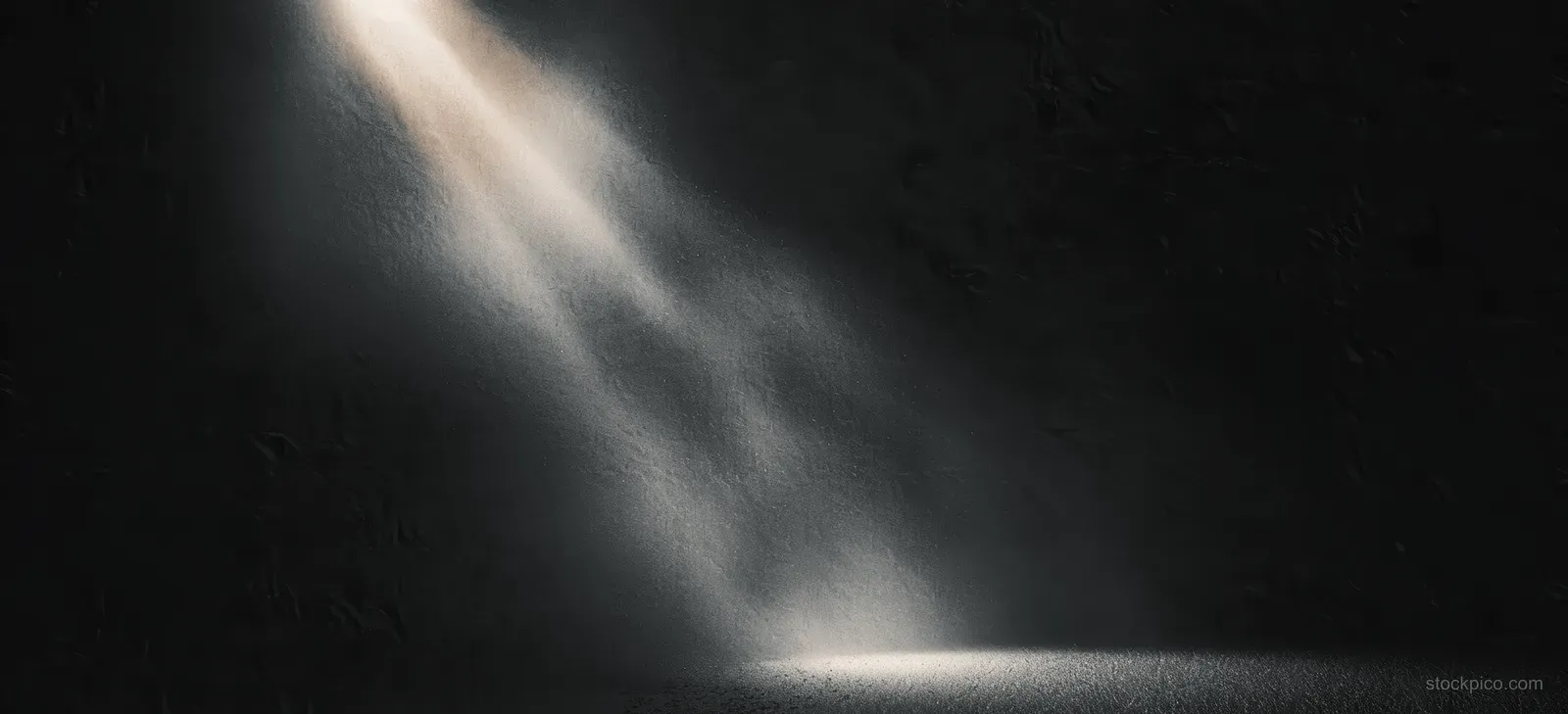 Glowing monochrome spotlight beams illuminate a dark grainy background with a soft abstract gradient shape.
