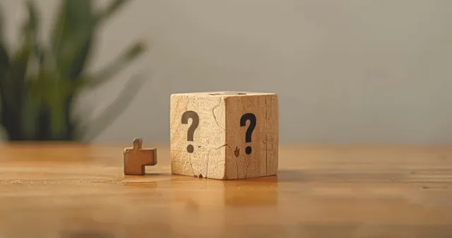 Wooden Q and A Cube with Question Marks on a Desk