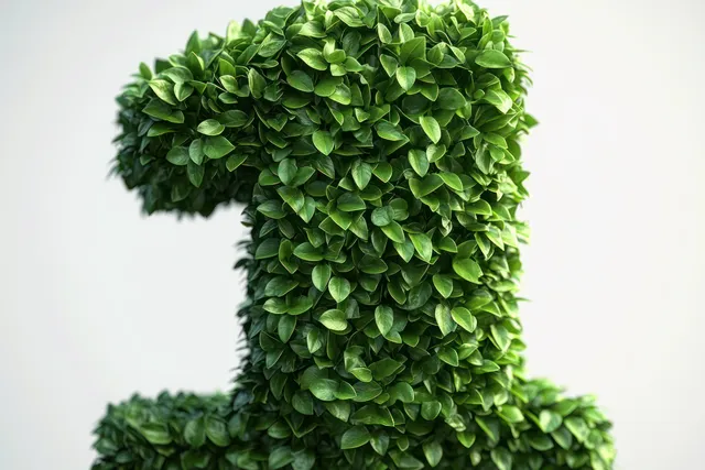 A dense green leafy sculpture forms the number one against a plain white background.