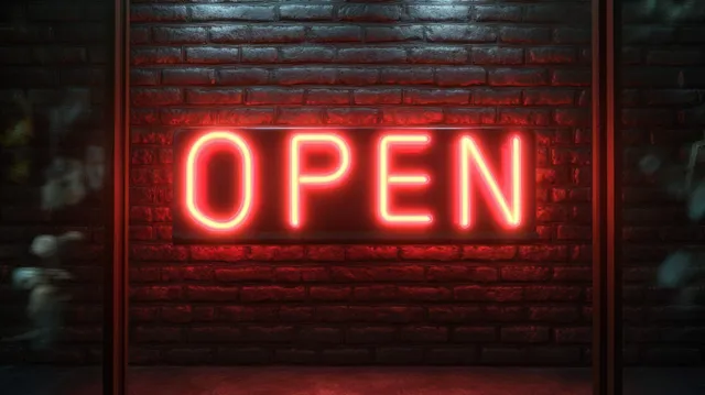 A red neon “OPEN” sign glows on a textured brick wall at night.