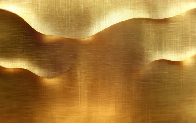 Curved gold metallic waves reflect warm light across a brushed textured surface.