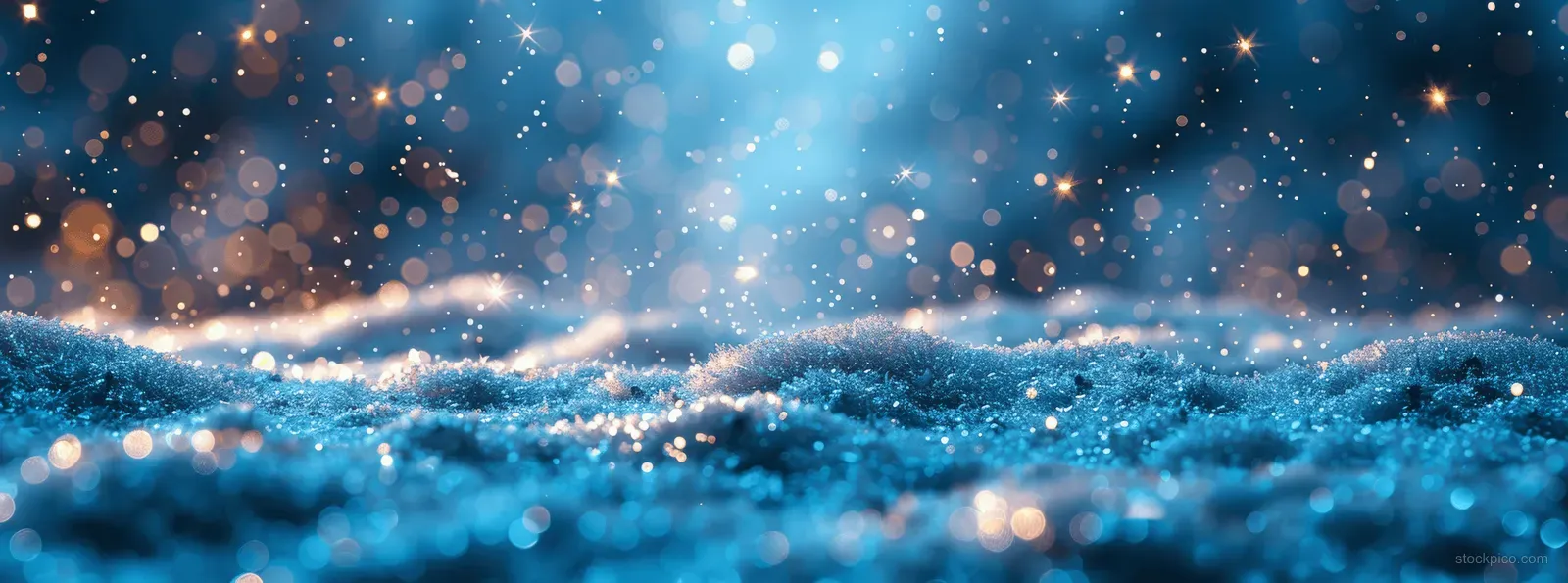 Snowflakes fall over blue snowdrifts as warm bokeh lights glow in the snowy night background.