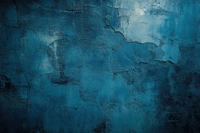 Close-up of a blue wall with cracked, peeling paint and rough weathered texture.