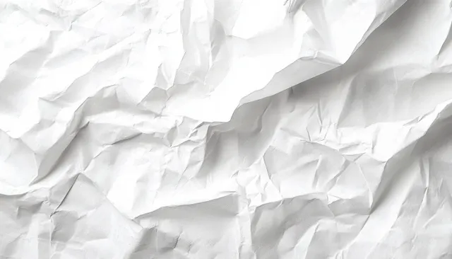 Crumpled white paper sheet with folded creases and distressed grunge texture backdrop