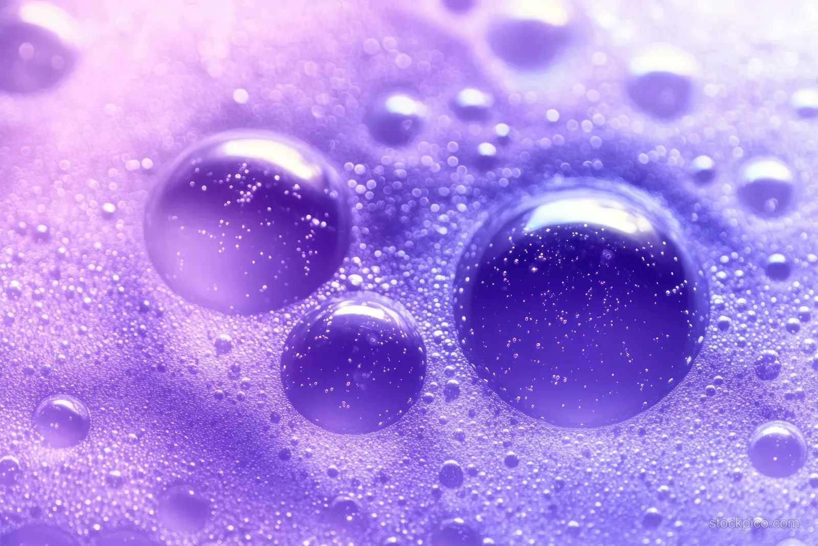 Purple violet liquid droplets and foam bubbles form glossy abstract spheres against a soft gradient background.