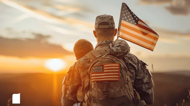 Camouflaged soldier holding a child with an American flag during a golden hour sunset.